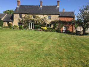 una casa vieja con un gran patio delante de ella en Mill Farm en Milton Keynes