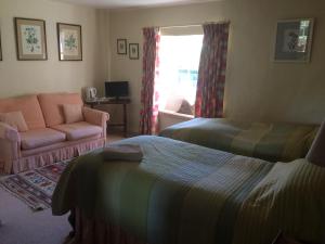 a bedroom with a bed and a couch and a window at Mill Farm in Milton Keynes