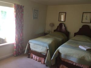 a bedroom with two beds and a window at Mill Farm in Milton Keynes
