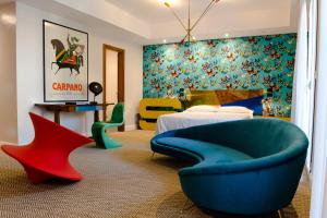 um quarto com uma cadeira azul e uma cama em Boutique Hotel Trieste - Adults Only em Verona