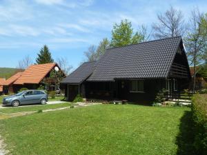 a black house with a car parked in front of it at Estavela Holiday home in Jezerce