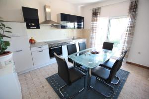 a kitchen with a glass table and chairs in it at Apartment Marin in Donji Seget