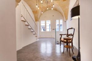 a hallway with a chair and a staircase at Petit Hotel 5 Fars in Ciutadella