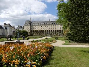 a large building with a garden in front of it at Gite Du Passant Rennais avec balcon sur cour in Rennes