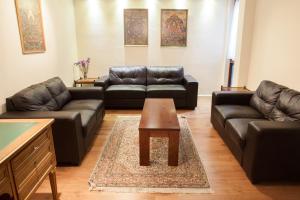 a living room with leather couches and a coffee table at Victoria and Buckingham Palace Apartments in London