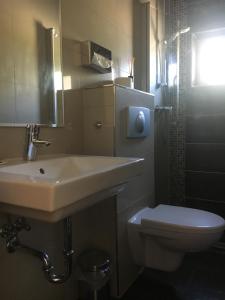 ein Bad mit einem Waschbecken und einem WC in der Unterkunft Adam Hotel in Giesen