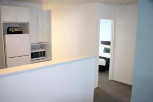 a kitchen with a white refrigerator and a microwave at Camelot On Ulster in Hamilton