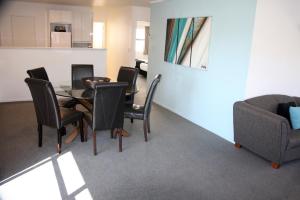 a dining room with a table and chairs and a couch at Camelot On Ulster in Hamilton