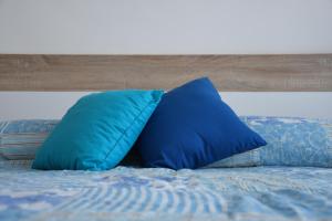 two blue pillows sitting on top of a bed at Apartman Moon in Zambratija