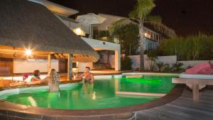 a group of people in a swimming pool at night at Lala Panzi B&B in Plettenberg Bay