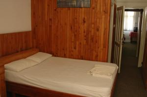 a bedroom with a bed with a wooden wall at Kiyak Hotel in Demre