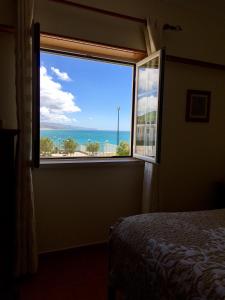 a bedroom with a window with a view of the ocean at Ericeira Lovers Apartment Center in Ericeira