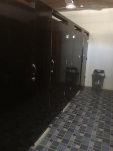 a bathroom with black doors and a tile floor at The Village Backpackers in Nuku‘alofa