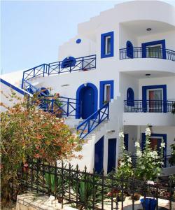 a blue and white building with blue stairs and plants at Psaras Apartments in Stalida
