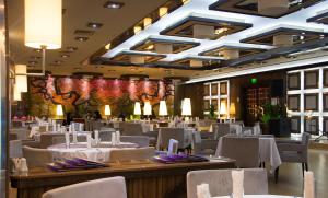a dining room with white tables and chairs at Hotel Cartoon Razgrad in Razgrad