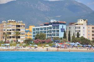 ein Strand mit Gebäuden und Menschen am Strand in der Unterkunft Blue Diamond Alya Hotel in Alanya