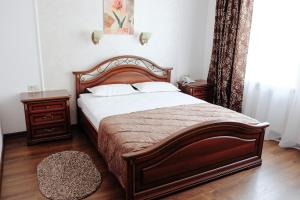 ハバロフスクにあるHotel Khabarovskのベッドルーム1室(大型木製ベッド1台、ナイトスタンド2台付)