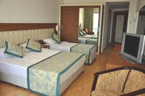 a hotel room with two beds and a television at Blue Diamond Alya Hotel in Alanya