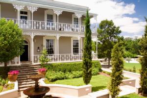 an exterior view of a house with a garden at Schoone Oordt Country House in Swellendam