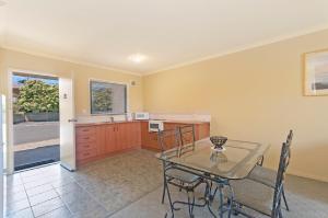 a kitchen and dining room with a table and chairs at Hopkins House Motel & Apartments in Warrnambool
