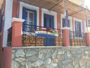 a building with a balcony with a sign on it at Nikolitsi Studios in Symi