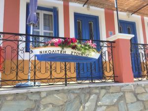 un balcone di una casa con un vaso di fiori di Nikolitsi Studios a Sými