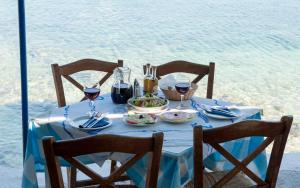 a table with a blue table cloth and wine glasses at La Grotta in Volímai