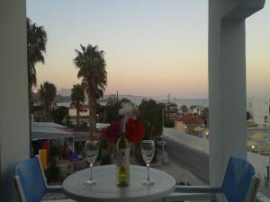 a table with two wine glasses and a view of a city at Antonis Hotel in Kefalos