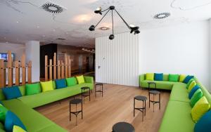 ein Wohnzimmer mit grünen Sofas und Hockern in der Unterkunft Vincci Bit in Barcelona