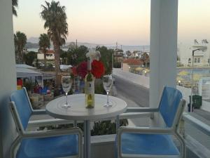 a table with two wine glasses on a balcony at Antonis Hotel in Kefalos