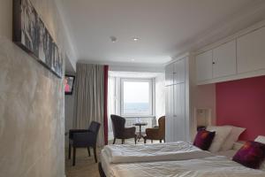 een hotelkamer met een bed en een tafel en stoelen bij Beach Hotel in De Haan