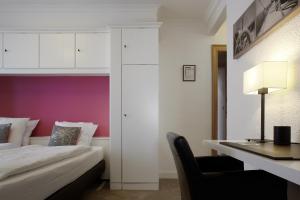 a bedroom with a bed and a desk with a chair at Beach Hotel in De Haan