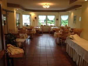 a dining room with tables and chairs and windows at Hotel Papp-Mühle in Zersen