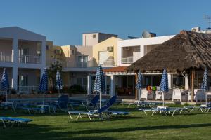 a group of lawn chairs and blue and white umbrellas at Evelin Hotel in Platanes