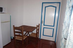 une cuisine avec une table et une porte bleue dans l'établissement Le Bleuet, à Saint-Leu
