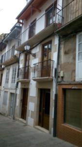um edifício com varandas do lado de uma rua em Apartamento con balcón em Viveiro