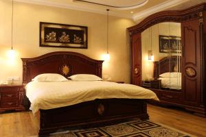 1 dormitorio con 1 cama grande y espejo grande en Atlas B&B Hotel, en Dushanbe