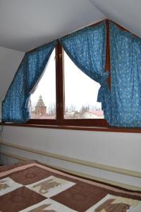 スーズダリにあるHoliday Home Old Suzdalのベッドルームの窓(青いカーテン付)