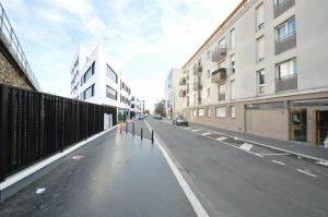 an empty street in a city with tall buildings at Paris Stade de France in Saint-Denis