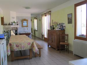 a living room with a table and a kitchen at Le Champ du Pré in Gièvres