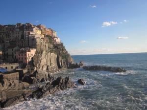 a view of a mountain with houses on the ocean at Cà di Boschetti Old Farm f in La Spezia
