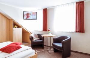 una camera d'albergo con letto e sedia di Pension Hotel Sartor a Kurort Altenberg
