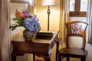 a vase of flowers on a table next to a chair at Taman Rahasia Tropical Sanctuary and Spa in Ubud