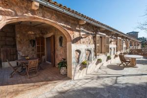 a building with a patio with a table and chairs at Agroturisme Son Llado in Campos