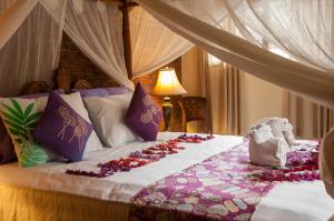 a bedroom with a bed with flowers on it at Taman Rahasia Tropical Sanctuary and Spa in Ubud