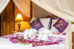 two stuffed elephants sitting on top of a bed at Taman Rahasia Tropical Sanctuary and Spa in Ubud