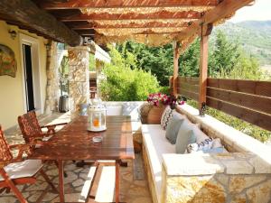 an outdoor patio with a wooden table and couch at Villa Victoria Boutique Apartments in Syvota