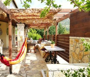 an outdoor patio with a hammock and a pergola at Villa Victoria Boutique Apartments in Sivota