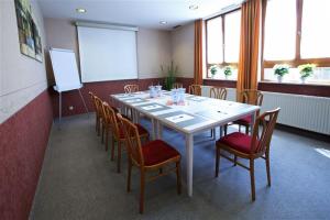 une salle de conférence avec une table et des chaises blanches dans l'établissement Hotel Ritter, à Bruchsal