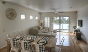a dining room and living room with a table and chairs at Beach Front Springs in Rosebud